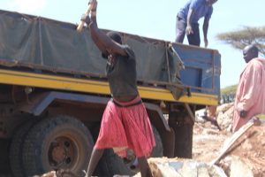Alice Loumo using all her energy to break stones at the mining site in Kosoroi Tapac subcounty